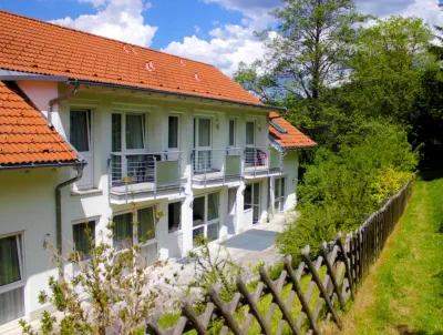 Rückansicht von Haus 1 mit Terrasse und Balkonen.